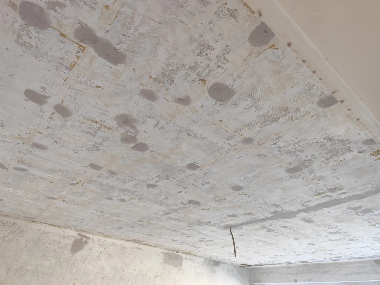 Rohe Betondecke vor dem Trockenbau, mit Spachtelstellen und sichtbaren Schalungsfugen